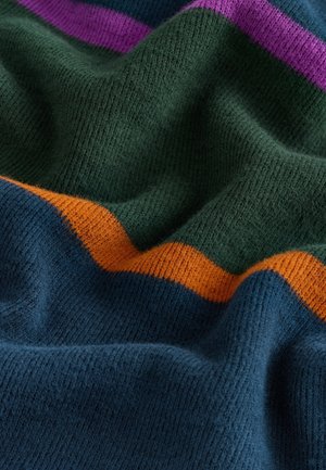 Mäkko pletená tkanina v tmavozelenej farbe s horizontálnymi pruhmi fialovej, oranžovej a námorníckej modrej. Textúra je mierne chlpatá so zamatovým vzhľadom.