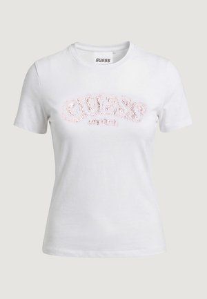 Maglietta bianca a maniche corte con scollo a girocollo, con il logo "GUESS" decorato con paillettes rosa sul petto.