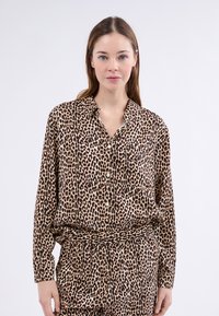 Pantterikuvioinen pitkähihaisissa paidassa on pehmeä kangas, kaulus ja napit, ja siinä on mukava väljä istuvuus, yhdistettynä yhteen sopiviin housuihin.