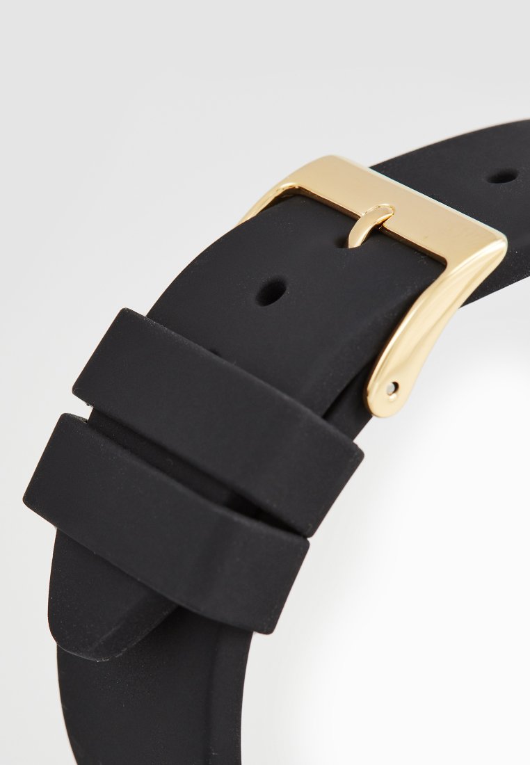 Zwarte silicone horlogeband met een gouden metalen sluiting, met een gladde textuur en twee verstelnotches. Eenvoudig ontwerp, geen patronen.