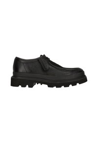 Zapato de cuero negro con un diseño clásico, que presenta un upper texturizado, suela gruesa de tacos y una solapa frontal con detalle del logo.