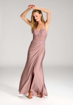 Abito lungo rosa con un corpetto aderente decorato con pizzi e trasparenze, tessuto drappeggiato e uno spacco alta sulla coscia. Design con spalline e una texture liscia.