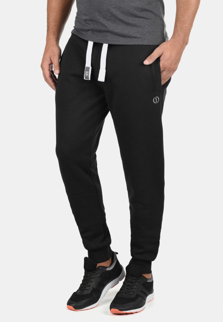 Zwarte sweats, taps toelopend ontwerp, rekbare katoen, elastische tailleband met witte trekkoorden, zijzakken en logodetail.
