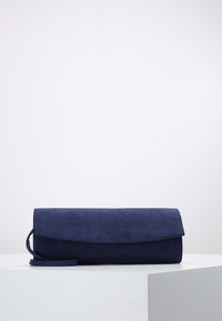 Pochette en daim bleu marine avec un rabat pliable et une bandoulière amovible. Texture lisse avec un design minimaliste, adaptée à diverses occasions.
