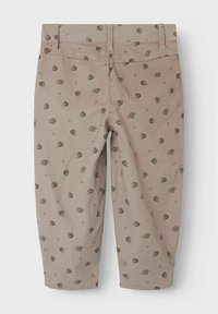 Pantaloni croppati beige in un tessuto testurizzato, caratterizzati da un motivo floreale ripetuto in marrone scuro e verde. Comprendono cinque passanti per cintura e una tasca posteriore.