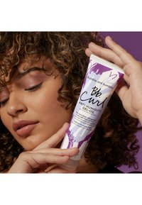 Bumble and Bumble anti-humidity gel-oil tuben har en lila och vit abstrakt design och ett spetsigt topp i ett flexibelt plastmaterial.