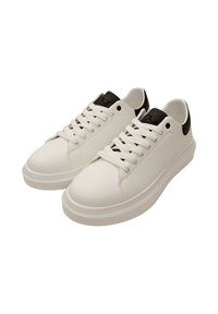 Sneaker bianche con finitura in pelle liscia, punta rotonda e accentuazione nera in contrasto sul tallone. Presentano lacci bianchi piatti e un branding minimal.