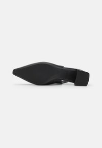 Black pointed-toe shoe with a low block heel. The material appears smooth with a matte finish and a rounded back strap for secure fitting.