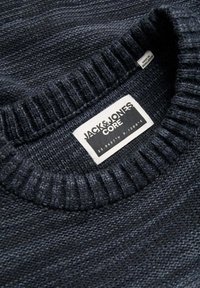 Dunkelblauer Strickpullover mit geripptem Kragen. Das Etikett lautet "JACK & JONES CORE." Das Material zeigt eine subtile Textur- und Mustervariation.