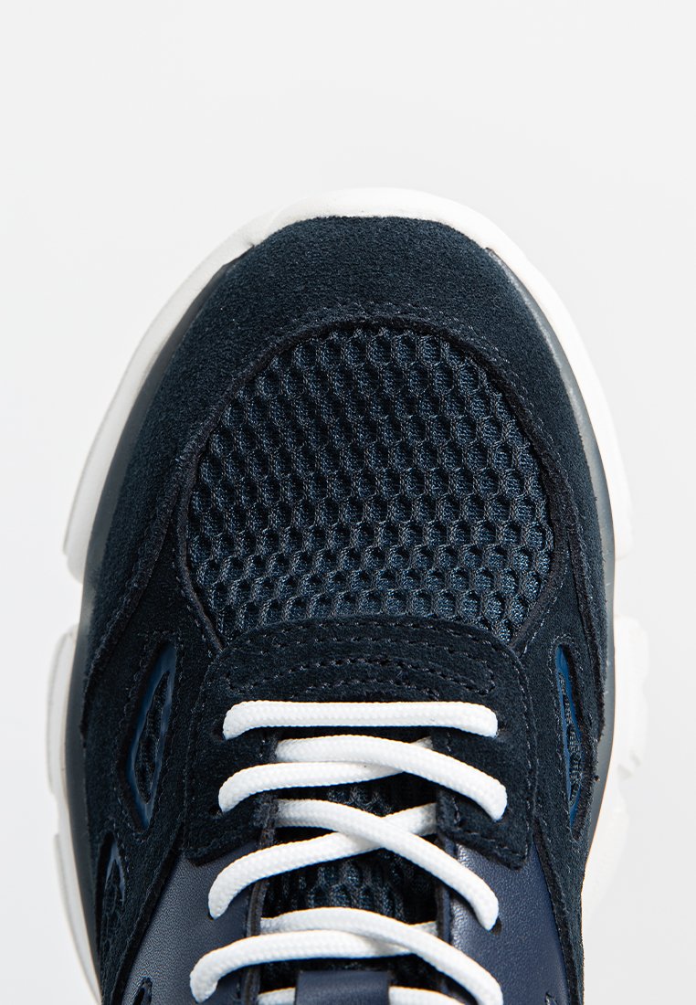 Obenansicht eines navyblauen Sneakers mit Mesh-Stoff, Wildleder-Overlays, weißen Schnürsenkeln und einer weißen Gummisohle.