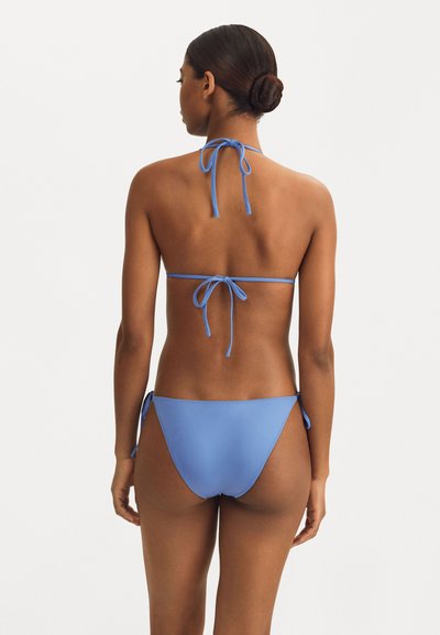 Zils bikini ar haltera kakla dizainu un saitēm. Mīksta, gluda auduma minimalisma stils, ar regulējamām saitēm augšā un apakšā.