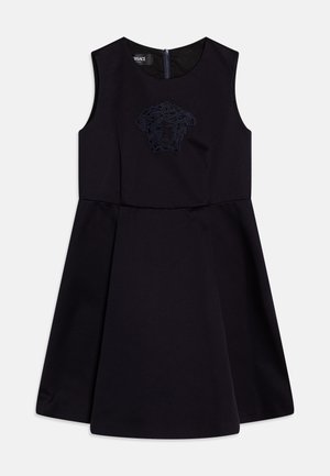Vestido negro sin mangas con falda acampanada, que presenta un logo de Medusa bordado en la parte delantera y un cierre de cremallera en la parte posterior.