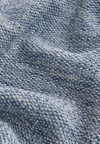 Tissu texturé dans différentes nuances de bleu, présentant un motif tissé avec une surface douce, légèrement en relief et un éclat subtil.