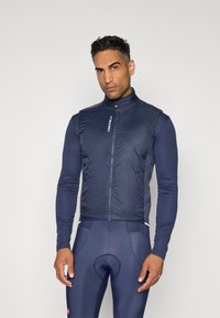 Chaleco de ciclismo azul marino con un cuello alto, cremallera frontal y material ligero. Acentuado por un logotipo y estilo ajustado para ropa activa.
