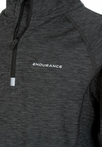 Zwarte rits-omgekeerde trui met een textuurafwerking en reflecterende accenten. Heeft het woord "ENDURANCE" in het wit op de borst.