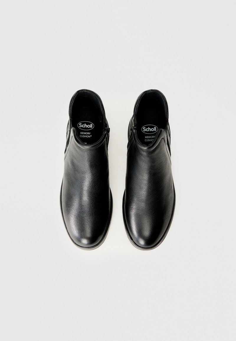 Stivali ankle in pelle nera con una texture liscia, punta rotonda e cerniere laterali. Presentano suole interne con cuscinetti in memoria per il massimo comfort.