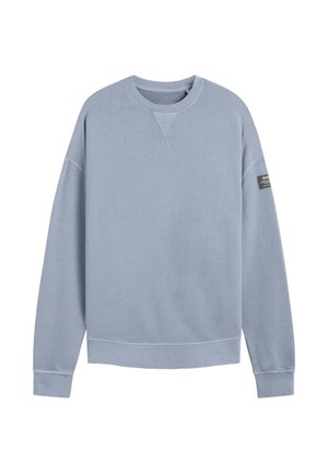 Sudadera azul clara con cuello redondo, puños y dobladillo acanalados, y un pequeño detalle de etiqueta negra en la manga izquierda. Textura de tela suave.