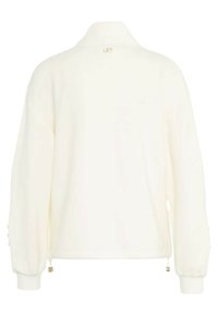 Giacca a pullover bianca con colletto, maniche lunghe e polsini elasticizzati. Presenta dettagli in metallo dorato e cordino all'orlo. Tessuto dalla texture liscia.