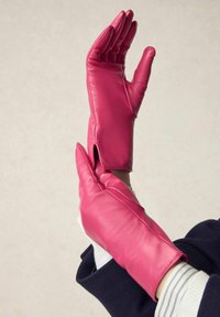 Fuchsia leather gloves with an elongated design, features a vent at the wrist, and structured fingers for a fitted appearance.