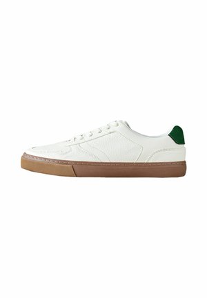 Witte lage sneaker met een bruine rubberen zool en een groene hieltab, een bovenwerk van getextureerd leer en witte veters, zijaanzicht.