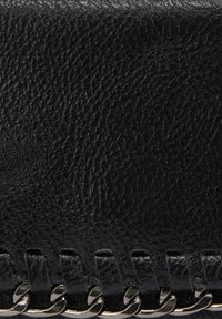Sort læderclutch med en tekstureret overflade, kædedetaljer og vævede accenter langs bunden for ekstra designinteresse.