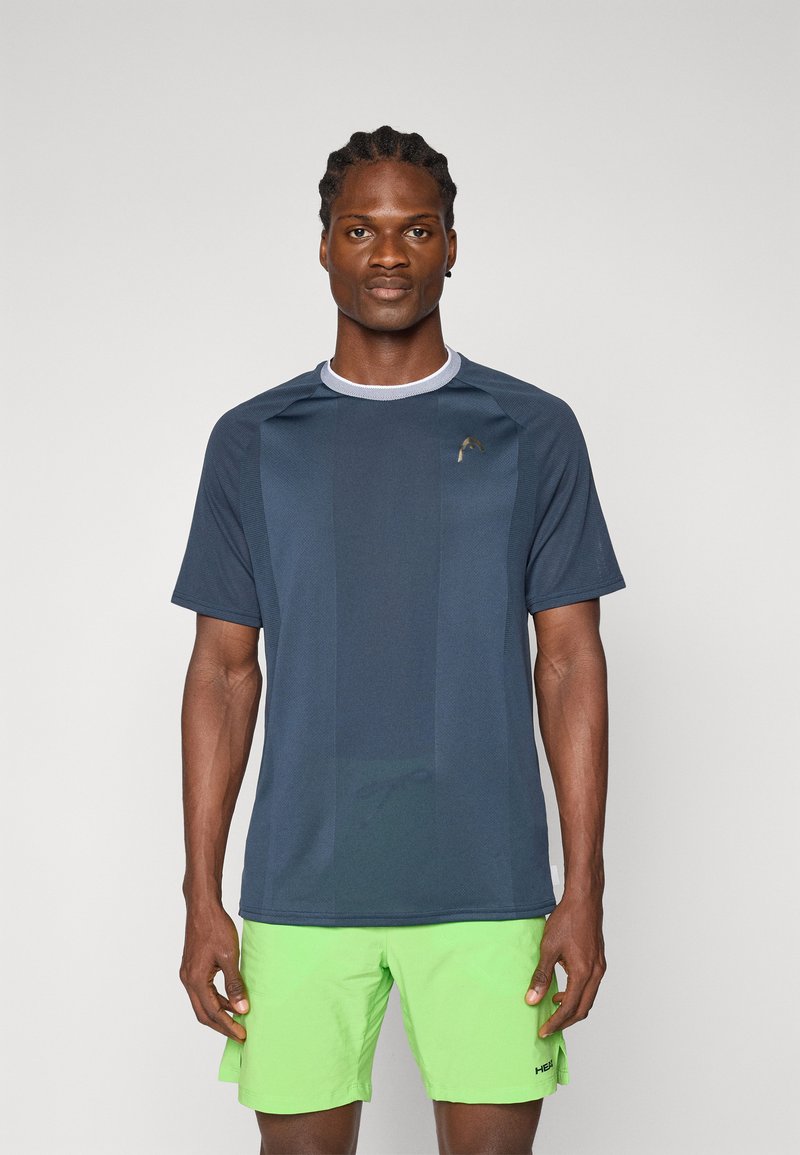 Camisa deportiva de color navy con mangas cortas y escote redondo, con un patrón texturizado. Combinada con pantalones cortos de color verde brillante para crear un contraste.