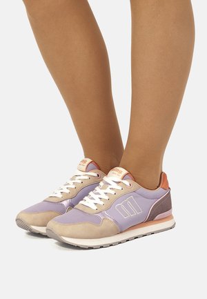 Lila-beige Sneaker mit glattem Textil-Obermaterial, weißen Schnürsenkeln und kontrastierender orangener Ferse. Auffälliges Logodetail an der Seite.
