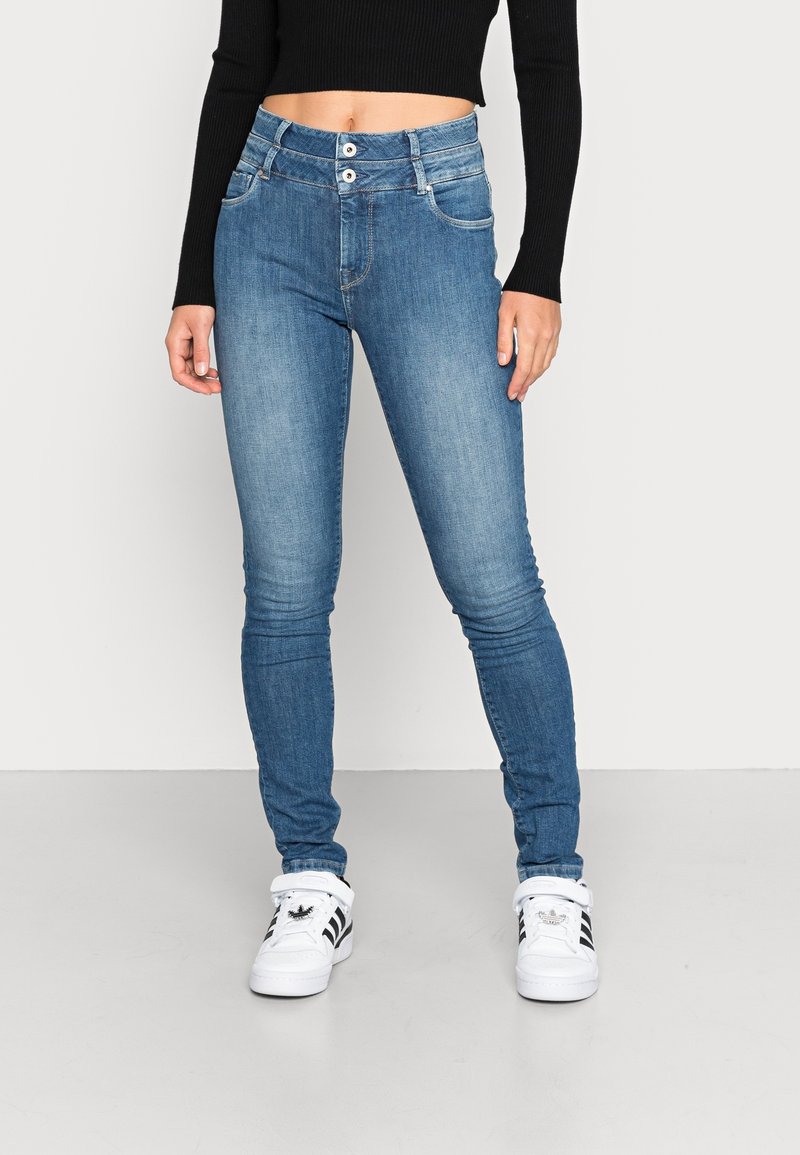 Träningstights i blekt blå denim, hög midja med dubbel knappstängning, fem fickor och lätt stretch för komfort.