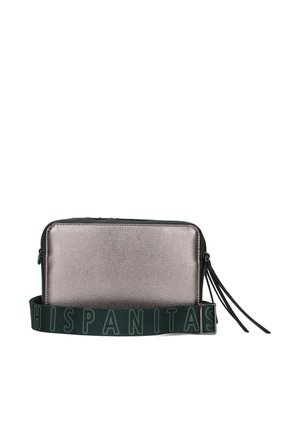 Metalen zilveren rechte tas met een textuur oppervlak, voorzien van een brede groene schouderband met witte lettering en twee zwarte kwastjes.