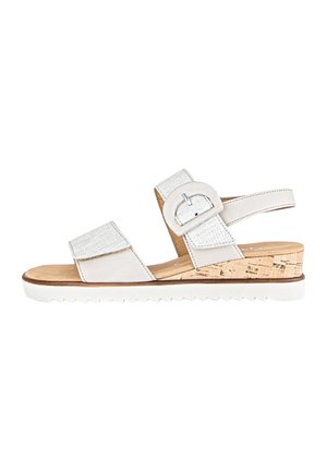White wedge sandal with cork heel, featuring adjustable straps and a textured fabric accent. Slightly textured footbed with a rubber outsole.