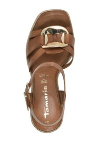 Sandal en cuir marron avec un design à large sangle, détail de boucle en ton doré, et une semelle texturée avec des accents tressés.