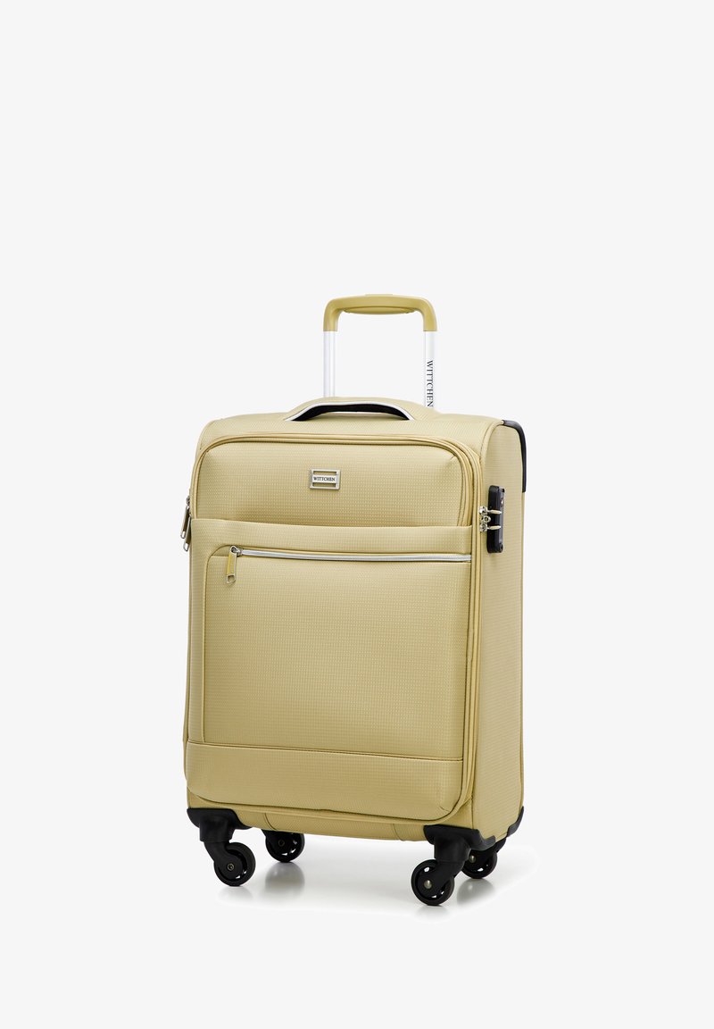 Harde koffer in lichtbeige met een gestructureerd oppervlak, dubbele rits, voorvak en vier zwarte wielen voor mobiliteit.