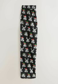 Fekete anyagból készült pizsamanadrág, amelyen ismétlődő mintákban viharmaszkos arcokat ábrázolnak, karácsonyi sapkával és agancsokkal díszítve, színes kiemelésekkel.