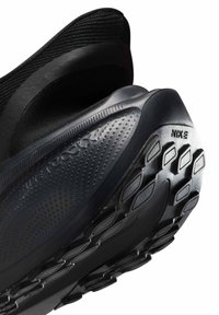 Crne atletske tenisice s teksturiranim gornjim dijelom i gumenim potplatom s uzorkom za bolje prianjanje, označene sa „Nike“ i „React“ brandingom.