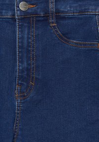 Tissu en denim bleu foncé avec des coutures visibles de couleur orange contrastante, doté d'une poche avant et d'une fermeture à bouton métallique.