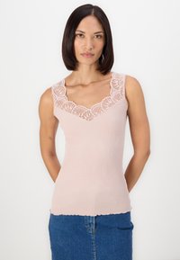 Light pink ribbed tank top featuring a floral lace trim along the neckline. The fabric has a soft texture with a scalloped hem at the bottom.
