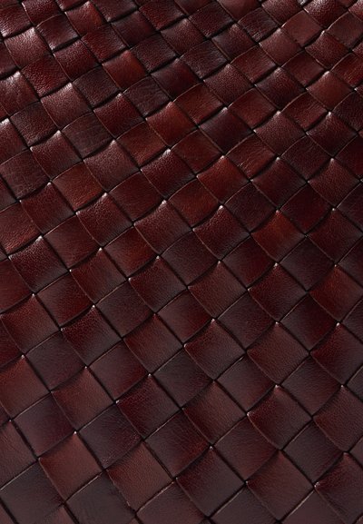 Υφασμάτινη επιφάνεια από δέρμα σε βαθύ μπορντό, με πλέγμα από διασταυρούμενα τετράγωνα και λεία, γυαλιστερή υφή.