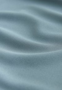 Tissu bleu clair doux et lisse avec des plis délicats et une texture finement tissée.