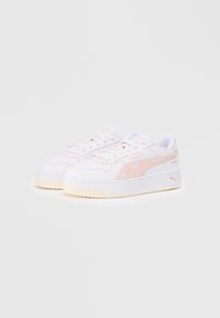 White sneakers with light pink accents, textured upper, chunky sole, and distinct Puma logo. Laced design with padded collar for comfort.