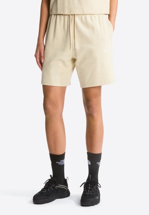 Beige Shorts aus Baumwollmischung mit elastischem Bund und Kordelzug. Verfügen über Seitentaschen und ein kleines weißes Logo am Oberschenkel.
