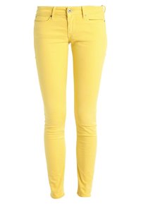 Jeans de mezclilla amarillos ajustados con una textura suave, cinco bolsillos, lazos para cinturón y un cierre frontal con botón y cremallera.