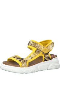 Yellow and black patterned sandals with adjustable straps, wide white soles, and open sides for ventilation. Textured accents on straps.