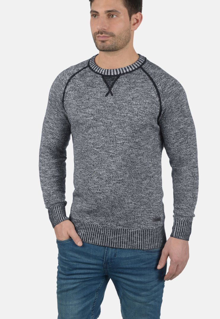 Maglione grigio a maglia con un motivo testurizzato, colletto rotondo a costine e polsini e orlo a costine di contrasto. Indossato con jeans blu.