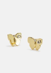 Pendientes en forma de mariposa de oro con un pequeño acento de gema clara y un detalle de plata. Superficie lisa con un acabado pulido.