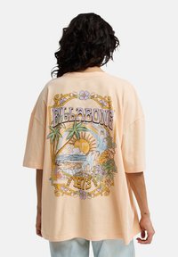 Μπλουζάκι Billabong oversized σε απαλό ροδακινί χρώμα, με πολύχρωμο σχέδιο που απεικονίζει φοίνικες, ήλιο και καταρράκτες. Κοντά μανίκια και άνετη εφαρμογή.