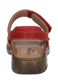 Rote Ledersandale mit zwei Riemen, einer gepolsterten Innensohle und einer flexiblen braunen Gummisohle. Verfügt über kontrastierende Nähte und verstellbare Verschlüsse.