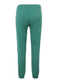 Gröna sweatpants i mjukt tyg, med elastisk midja, avslutade anklar och en liten logodetalj nära midjan.