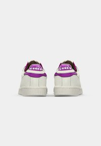 Hvite lær sneakers med lilla hæltot og logo, strukturert overflate og gummisåle med ribbet detaljer.