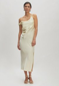 Ärmelloses, cremefarbenes Satin-Kleid mit einem seitlichen Schlitz; verfügt über ein leicht drapiertes Design und verstellbare Spaghetti-Träger.