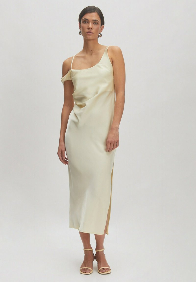 Ärmelloses, cremefarbenes Satin-Kleid mit einem seitlichen Schlitz; verfügt über ein leicht drapiertes Design und verstellbare Spaghetti-Träger.